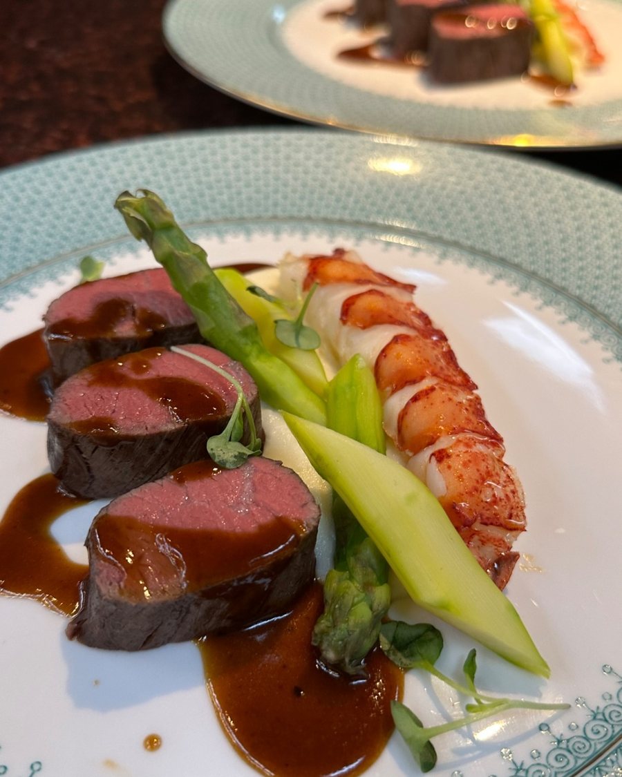 Beef tenderloin and lobster plated together with asparagus