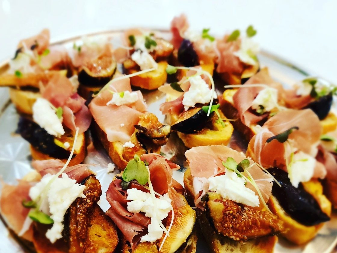 Crostini under figs, prosciutto and burrata, dressed with balsamic