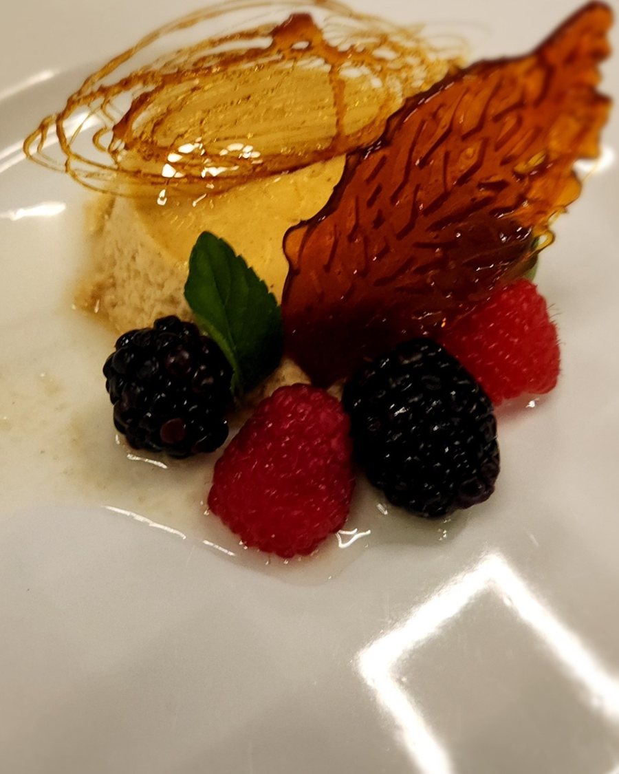 A set custard with a spun-sugar tuile, raspberries and blackberries